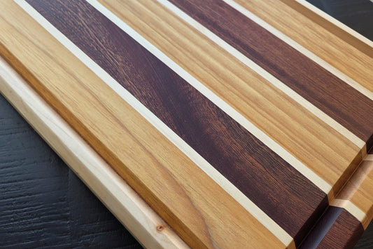 Wooden cutting board with striped pattern on a dark surface